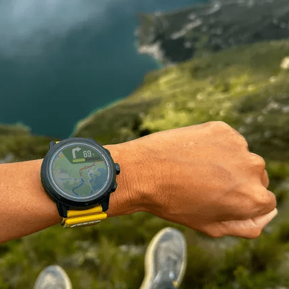 Coros watch on wrist on top of mountain
